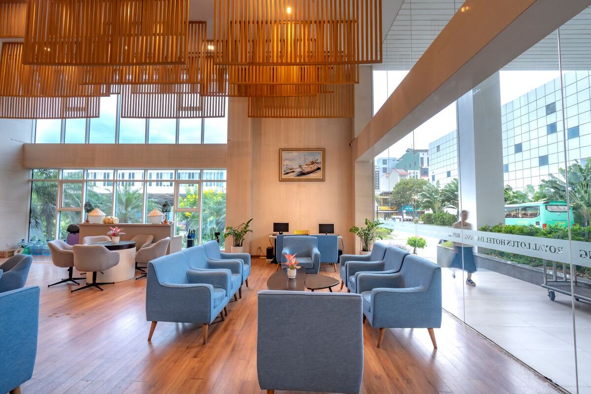 A bright office lobby with blue armchairs and a wood ceiling